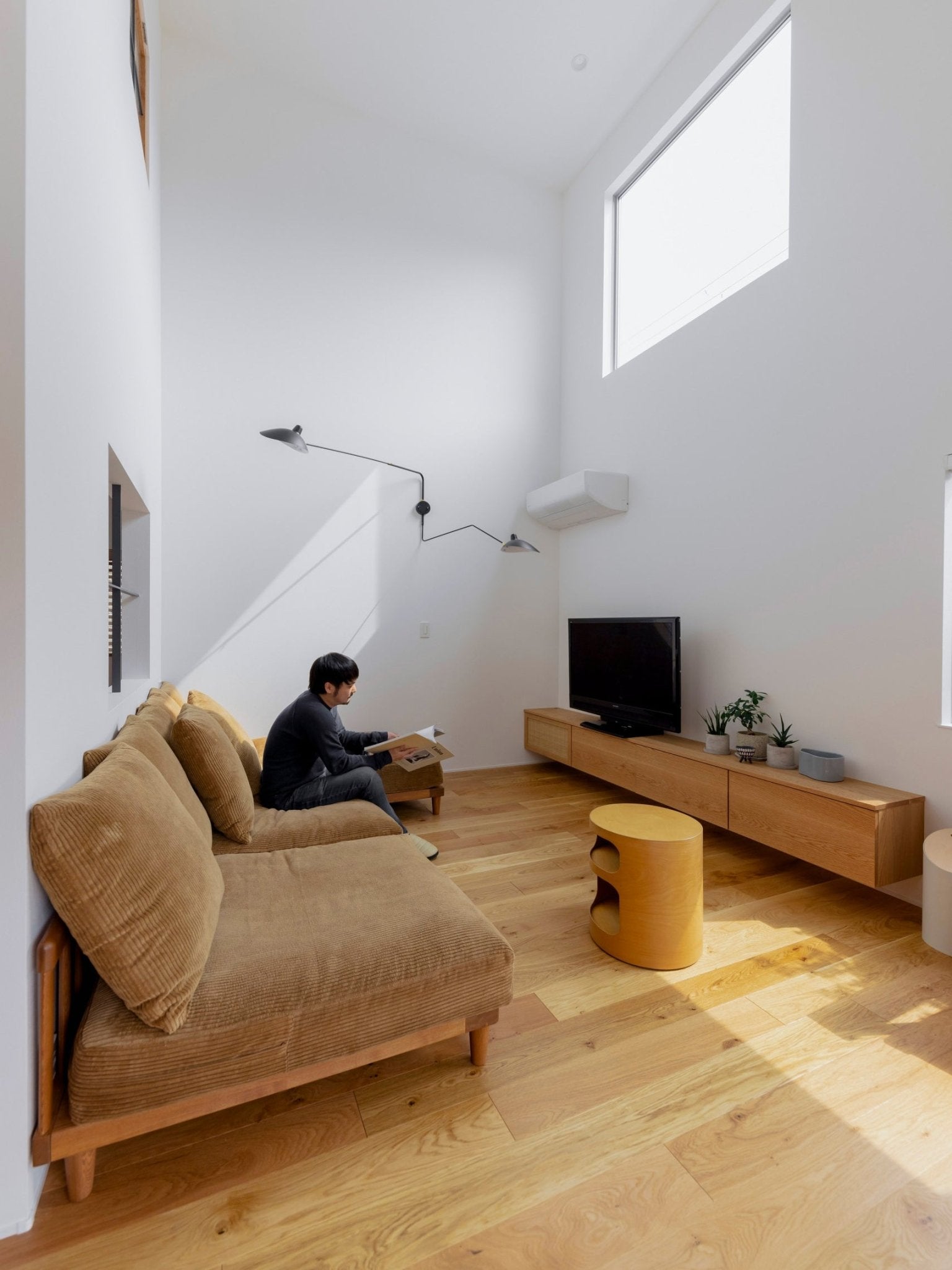 "Elegant Serge Mouille vegglampe med justerbar arm, insektlignende design, passer moderne innredning i svart eller hvit."