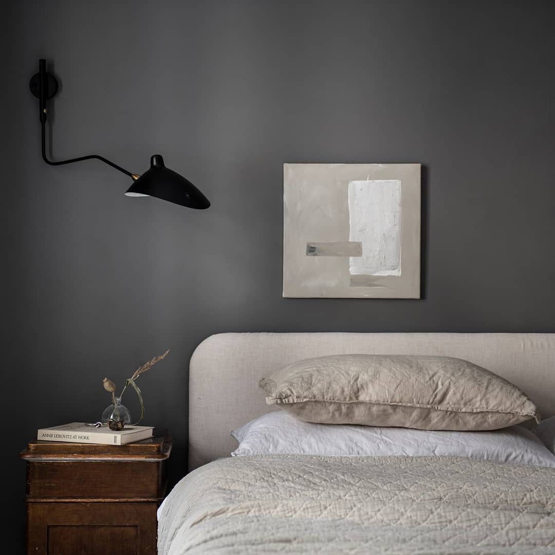 "Elegant Serge Mouille vegglampe med justerbar arm, insektlignende design, passer moderne innredning i svart eller hvit."