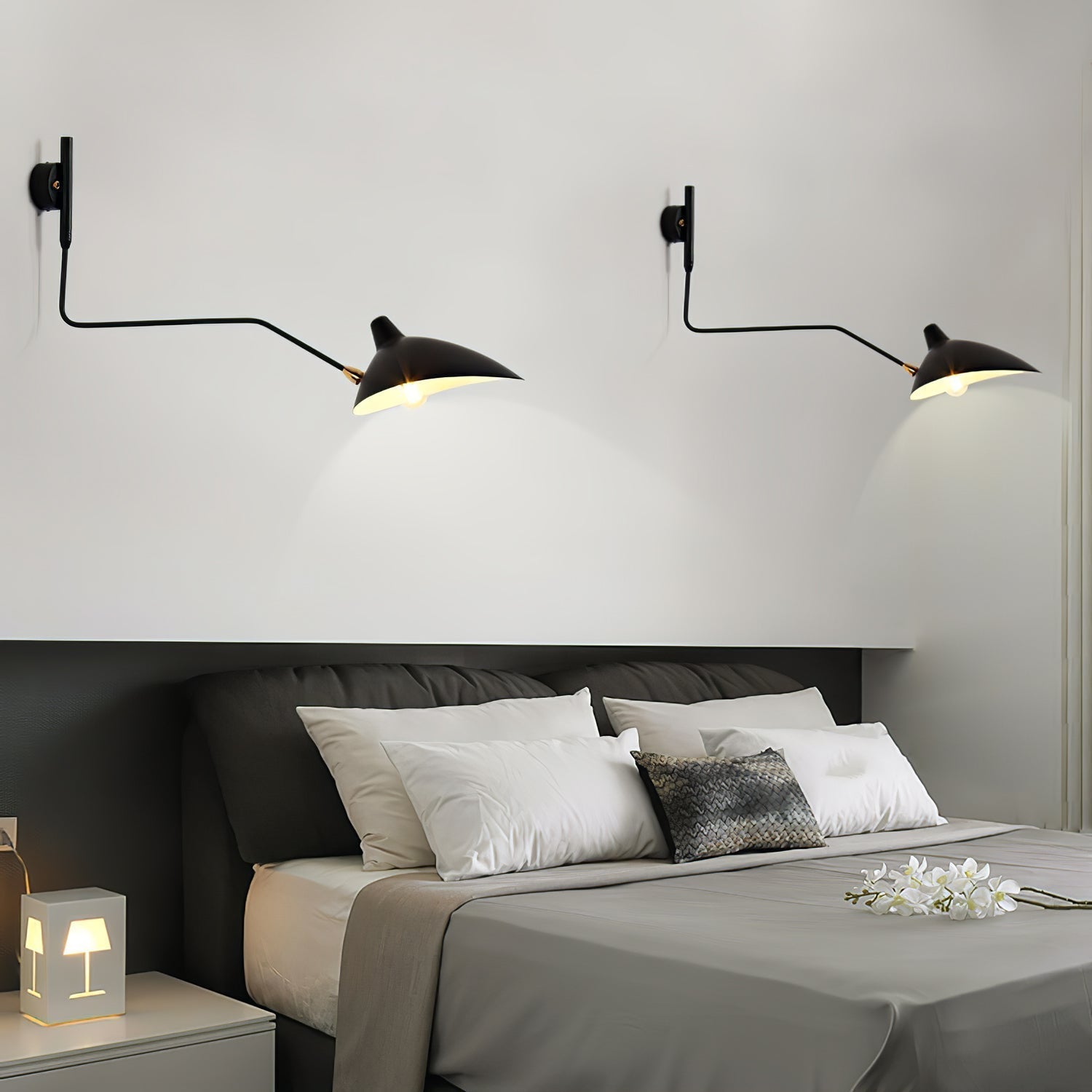 "Elegant Serge Mouille vegglampe med justerbar arm, insektlignende design, passer moderne innredning i svart eller hvit."