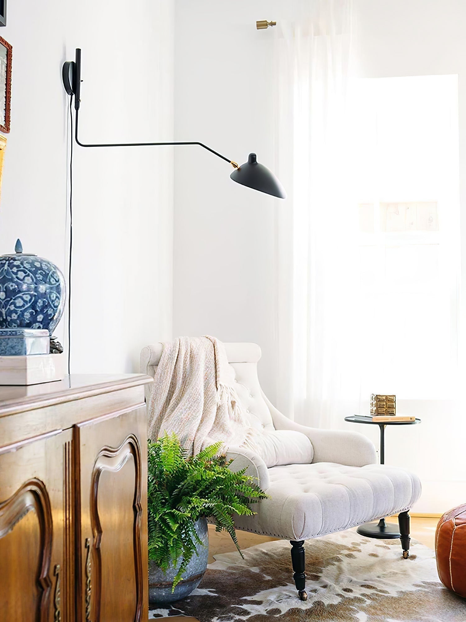 "Elegant Serge Mouille vegglampe med justerbar arm, insektlignende design, passer moderne innredning i svart eller hvit."