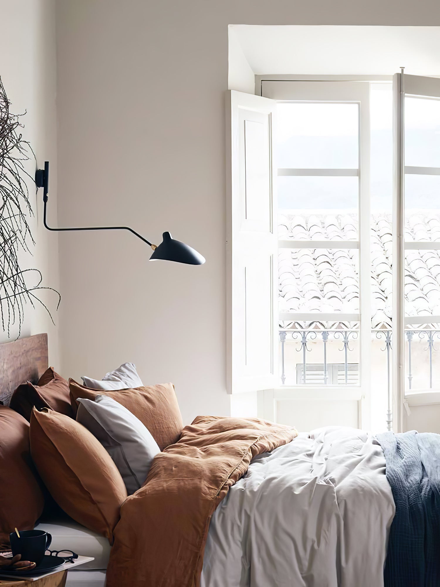 "Elegant Serge Mouille vegglampe med justerbar arm, insektlignende design, passer moderne innredning i svart eller hvit."