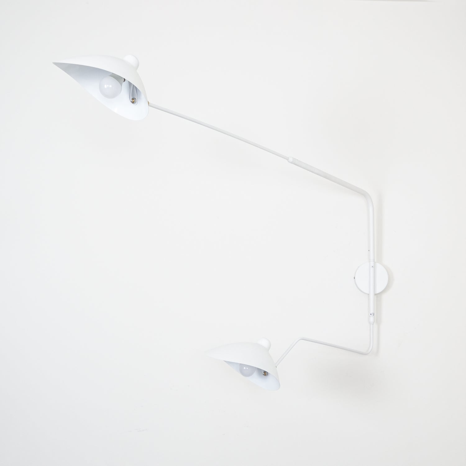 "Elegant Serge Mouille vegglampe med justerbar arm, insektlignende design, passer moderne innredning i svart eller hvit."