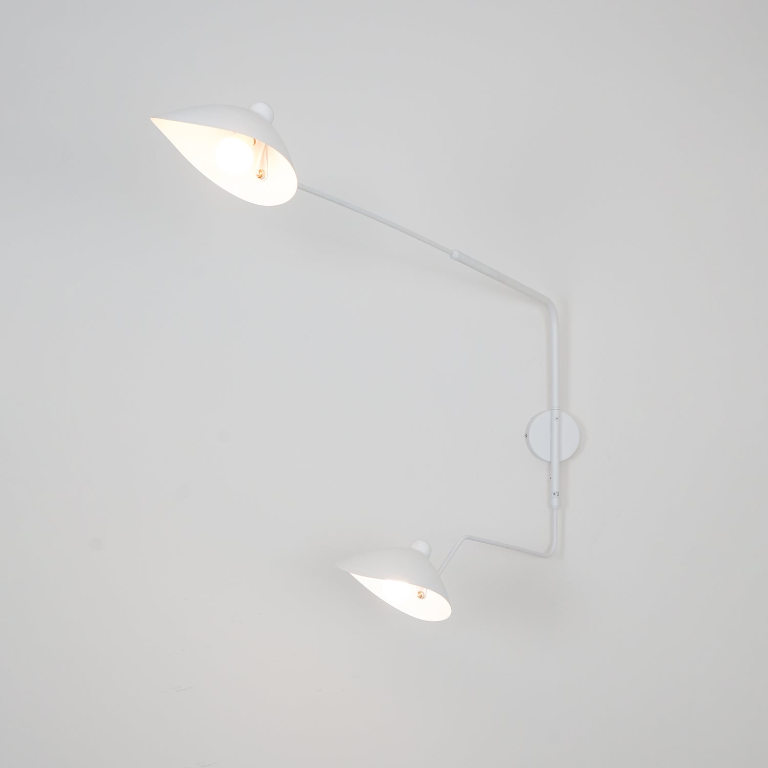 "Elegant Serge Mouille vegglampe med justerbar arm, insektlignende design, passer moderne innredning i svart eller hvit."