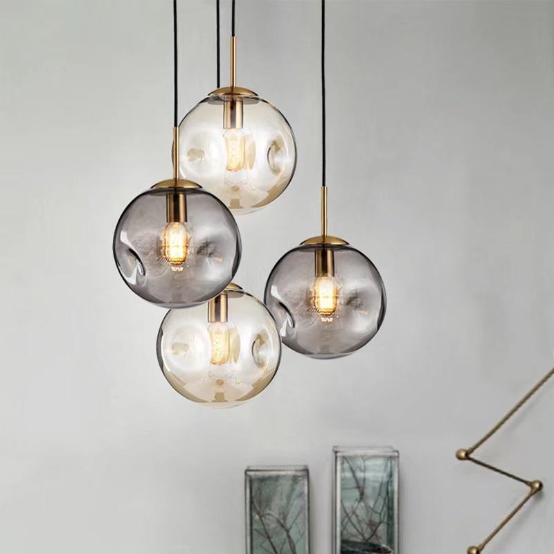 "Elegant sfærisk glasspendellampe med gullfinish, nordisk design, jevn lysfordeling, passer for moderne innemiljøer."