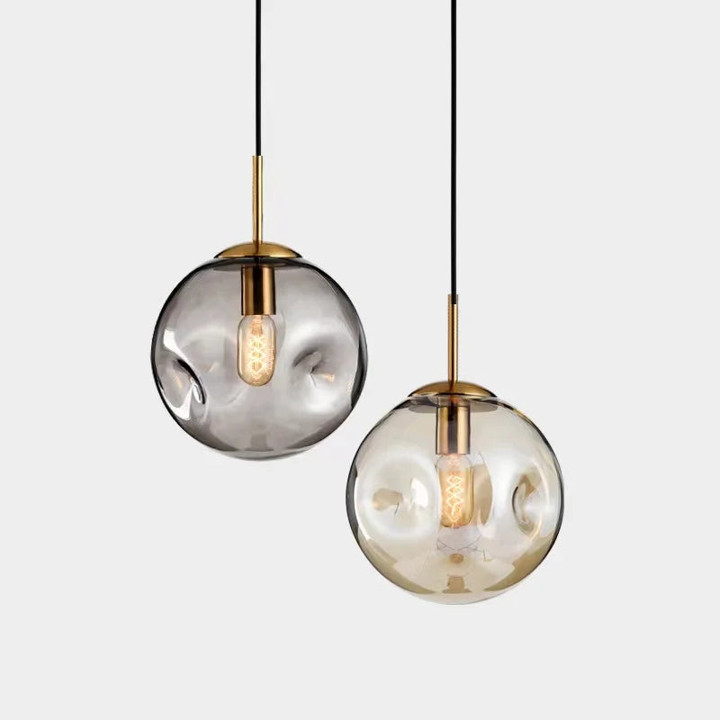 "Elegant sfærisk glasspendellampe med gullfinish, nordisk design, jevn lysfordeling, passer for moderne innemiljøer."