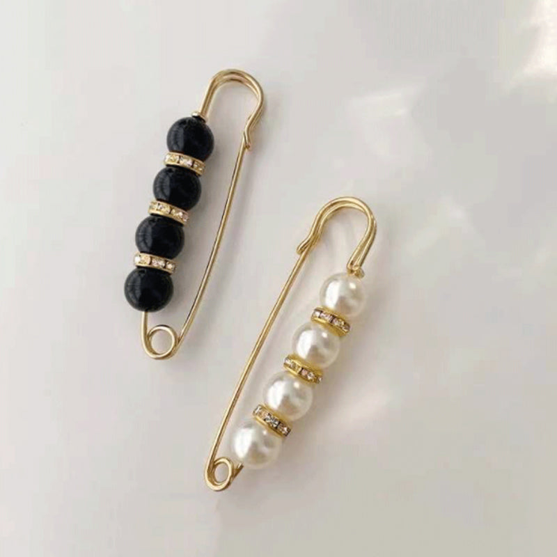 "Elegant sikkerhetsnålsbrosje med perler og rhinestones, perfekt for kjoler og skjerf, i svart og hvitt."