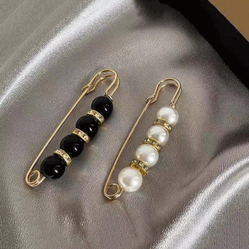 "Elegant sikkerhetsnålsbrosje med perler og rhinestones, perfekt for kjoler og skjerf, i svart og hvitt."