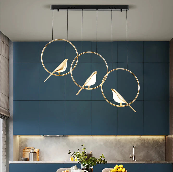 "Elegant taklampe med gylne fugler i justerbar design; metallisk finish, lyseffekt gir luksuriøs atmosfære."