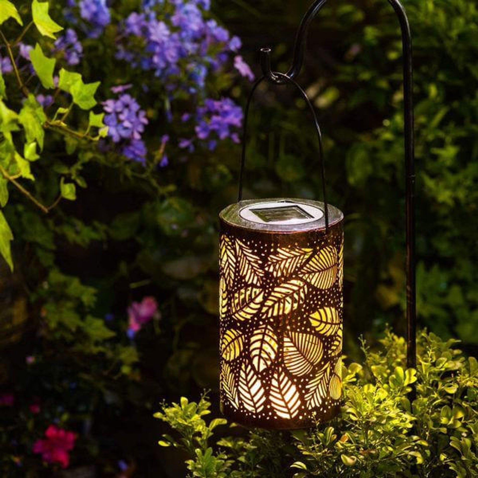 "Elegant utendørs lanterne med unik bladdekor, skaper lysmønster, værbestandig, perfekt for hage og terrasse."