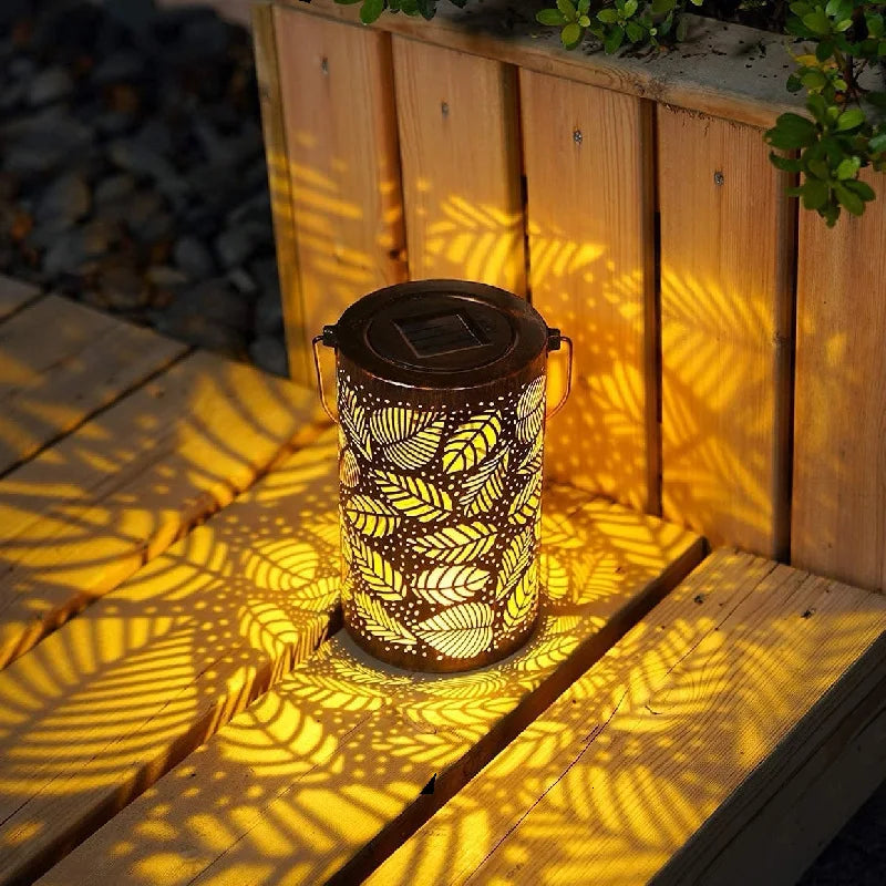 "Elegant utendørs lanterne med unik bladdekor, skaper lysmønster, værbestandig, perfekt for hage og terrasse."
