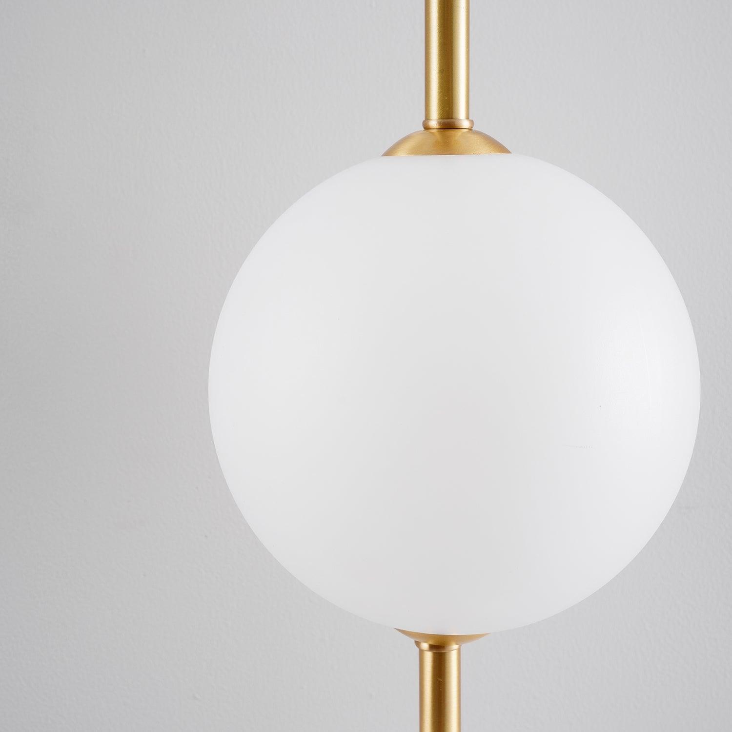 "Elegant vegglampe i glass og messing med kuleformede skjermer for mykt lys, perfekt for moderne og klassiske hjem."