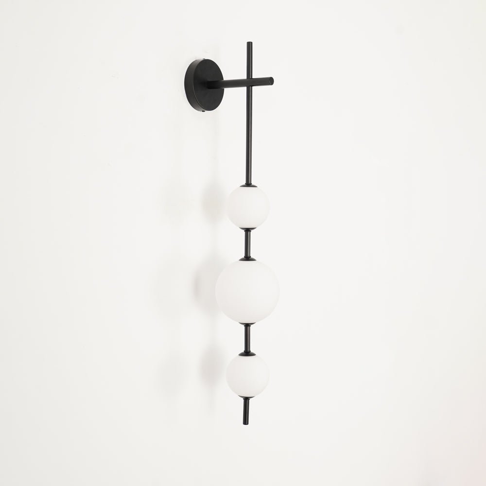 "Elegant vegglampe i glass og messing med kuleformede skjermer for mykt lys, perfekt for moderne og klassiske hjem."