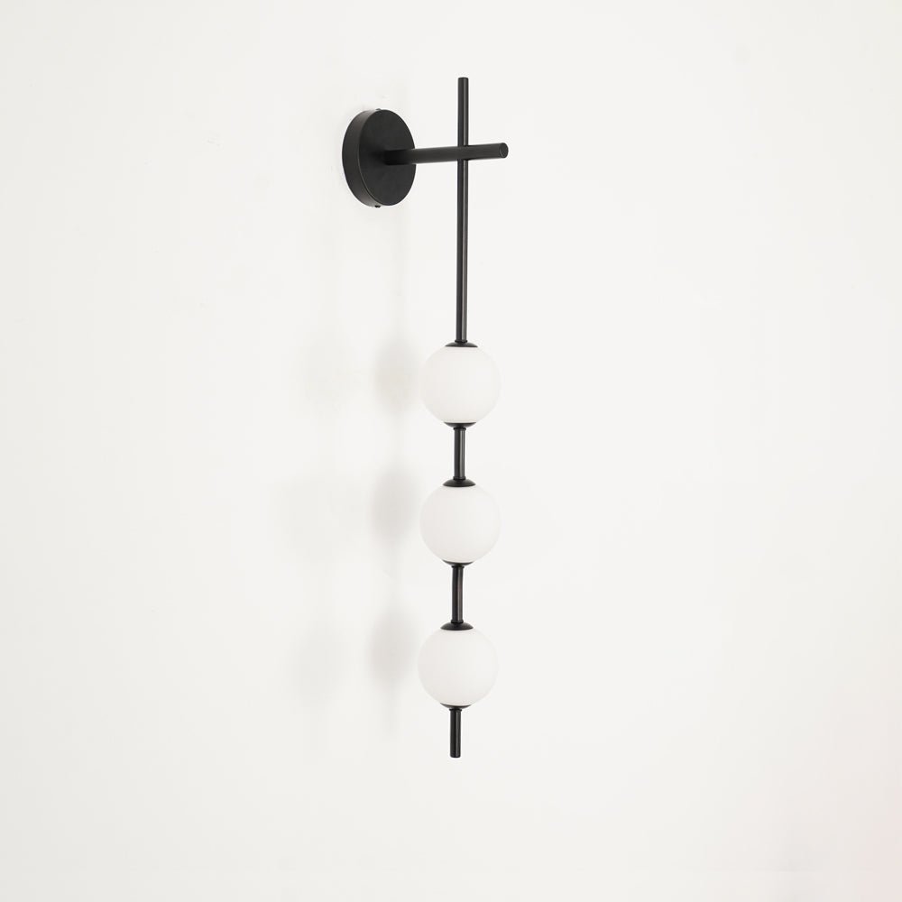 "Elegant vegglampe i glass og messing med kuleformede skjermer for mykt lys, perfekt for moderne og klassiske hjem."