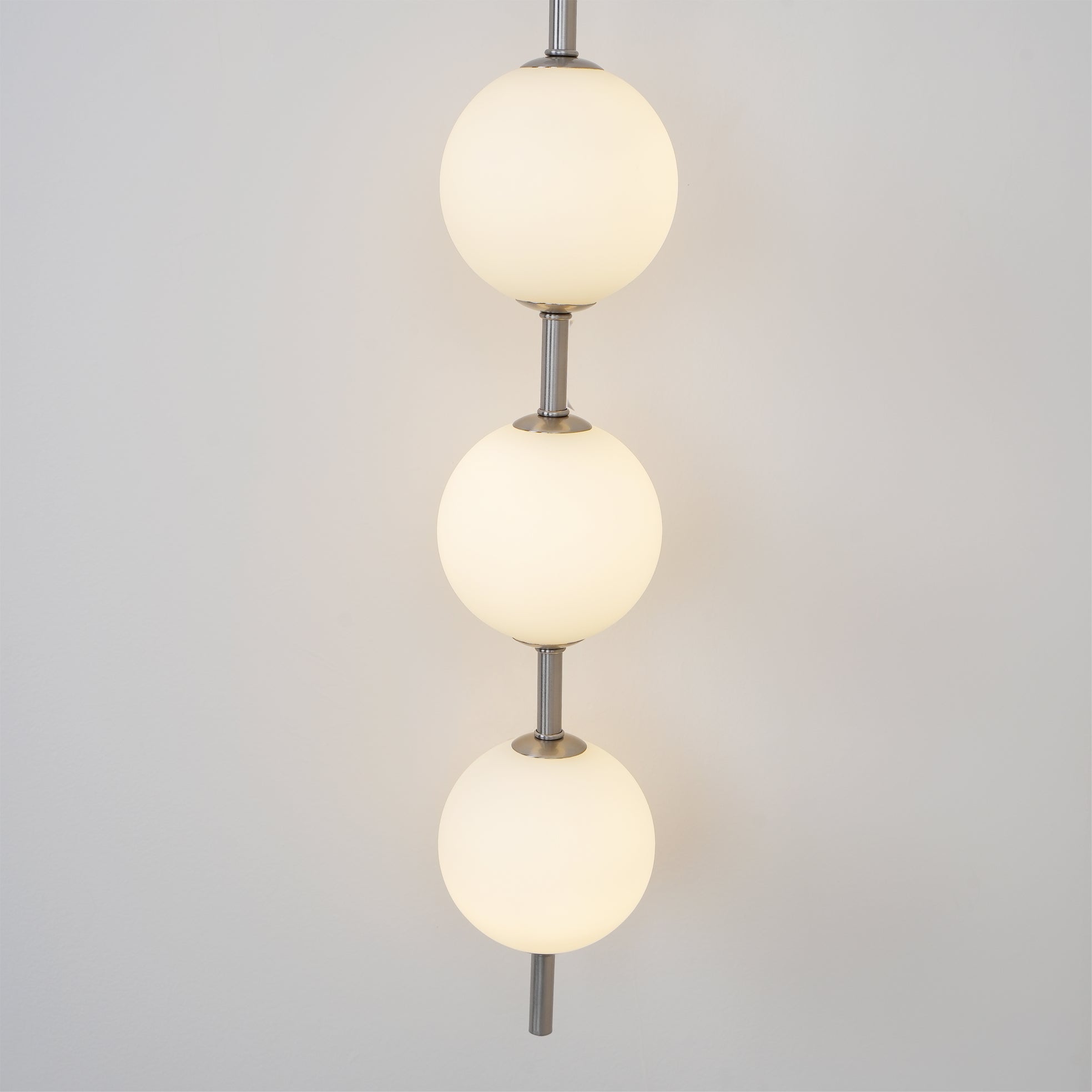 "Elegant vegglampe i glass og messing med kuleformede skjermer for mykt lys, perfekt for moderne og klassiske hjem."