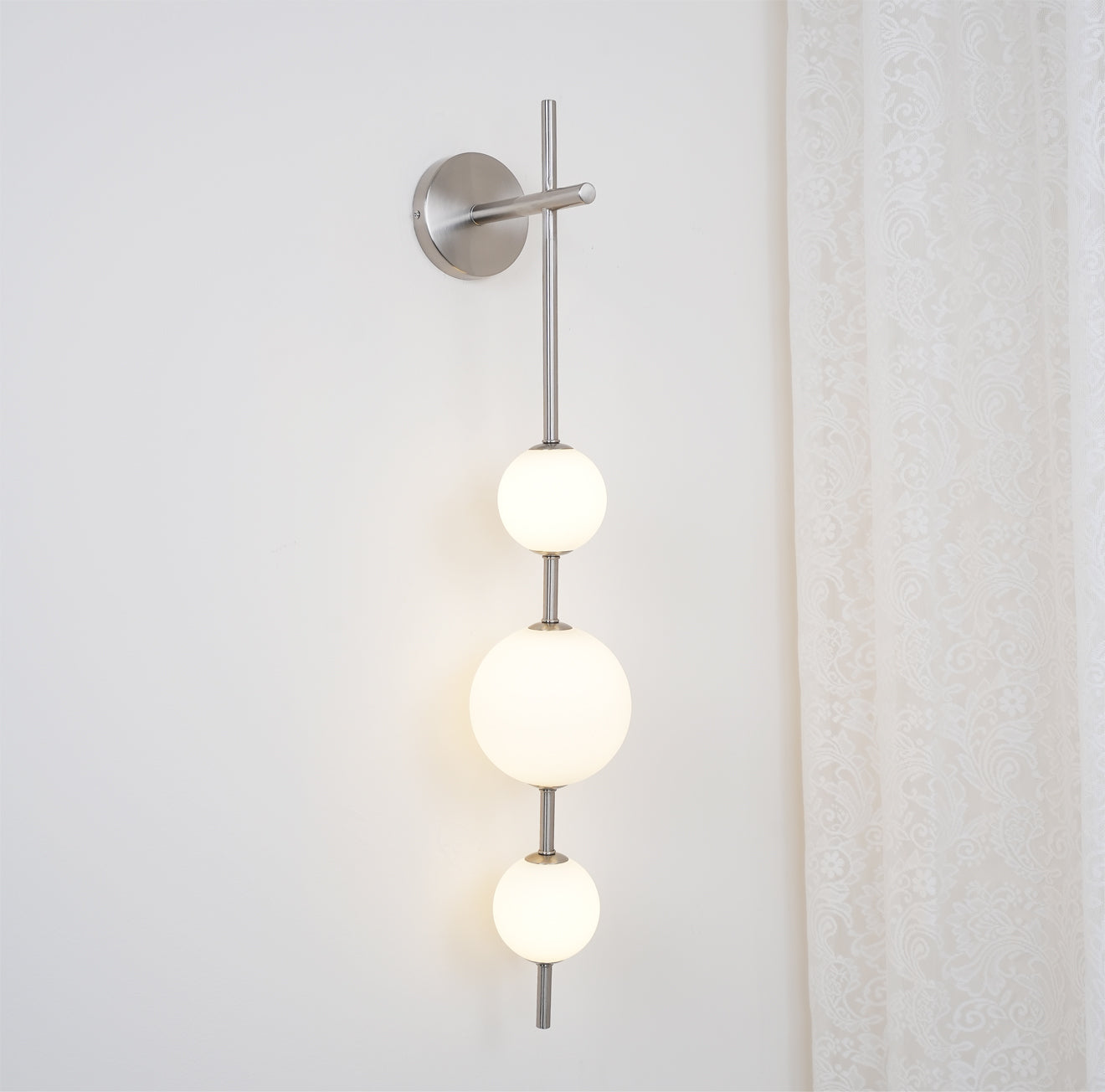"Elegant vegglampe i glass og messing med kuleformede skjermer for mykt lys, perfekt for moderne og klassiske hjem."