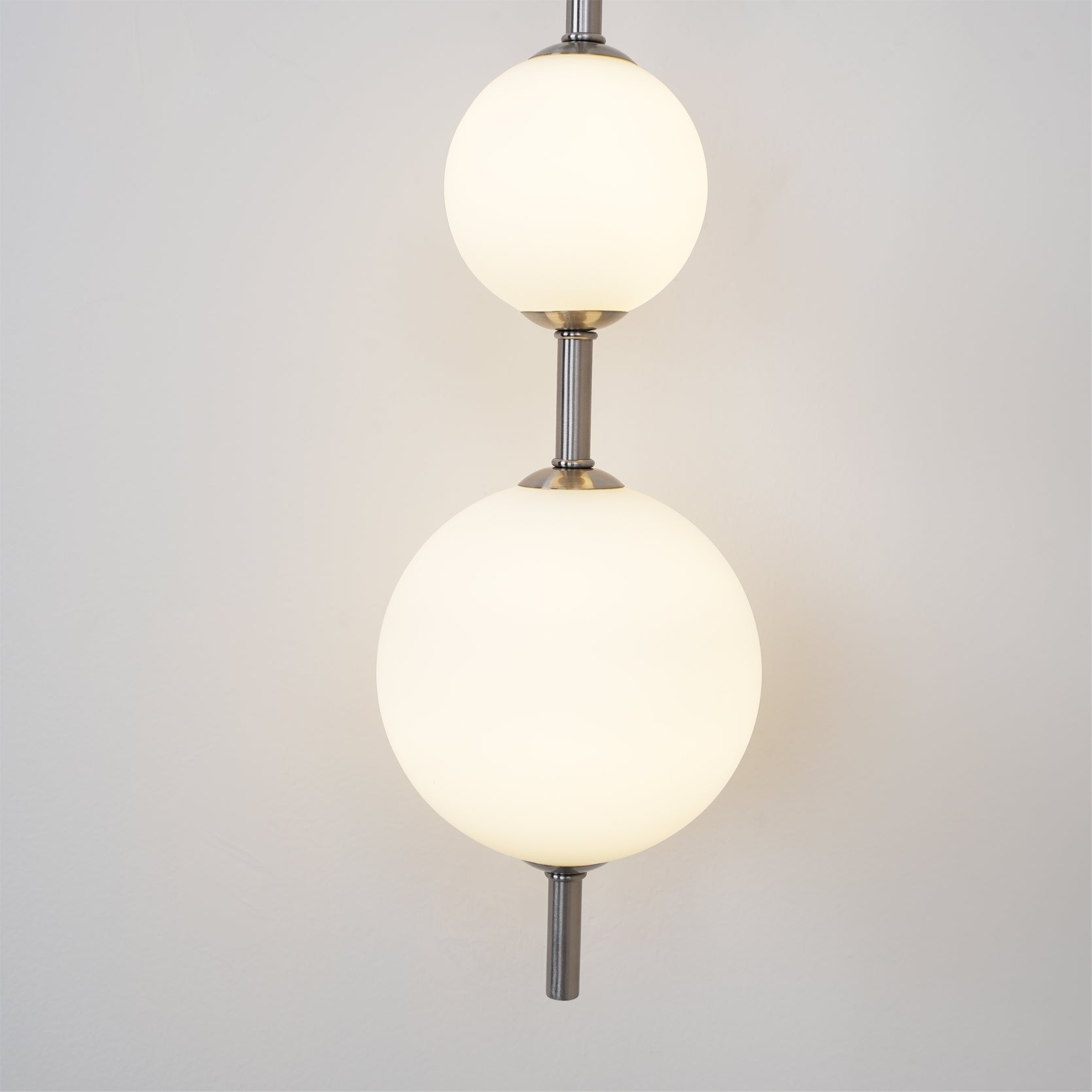 "Elegant vegglampe i glass og messing med kuleformede skjermer for mykt lys, perfekt for moderne og klassiske hjem."
