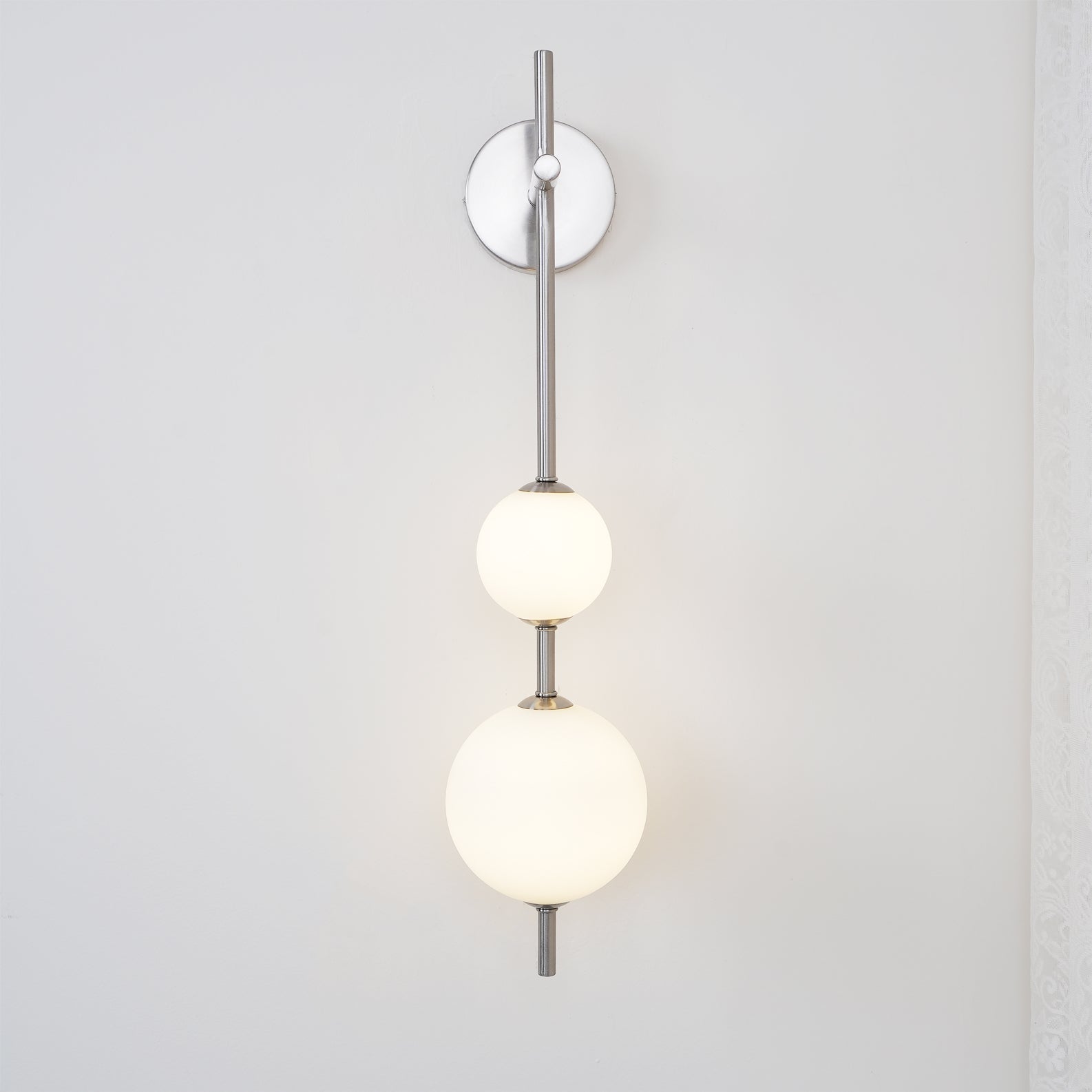 "Elegant vegglampe i glass og messing med kuleformede skjermer for mykt lys, perfekt for moderne og klassiske hjem."