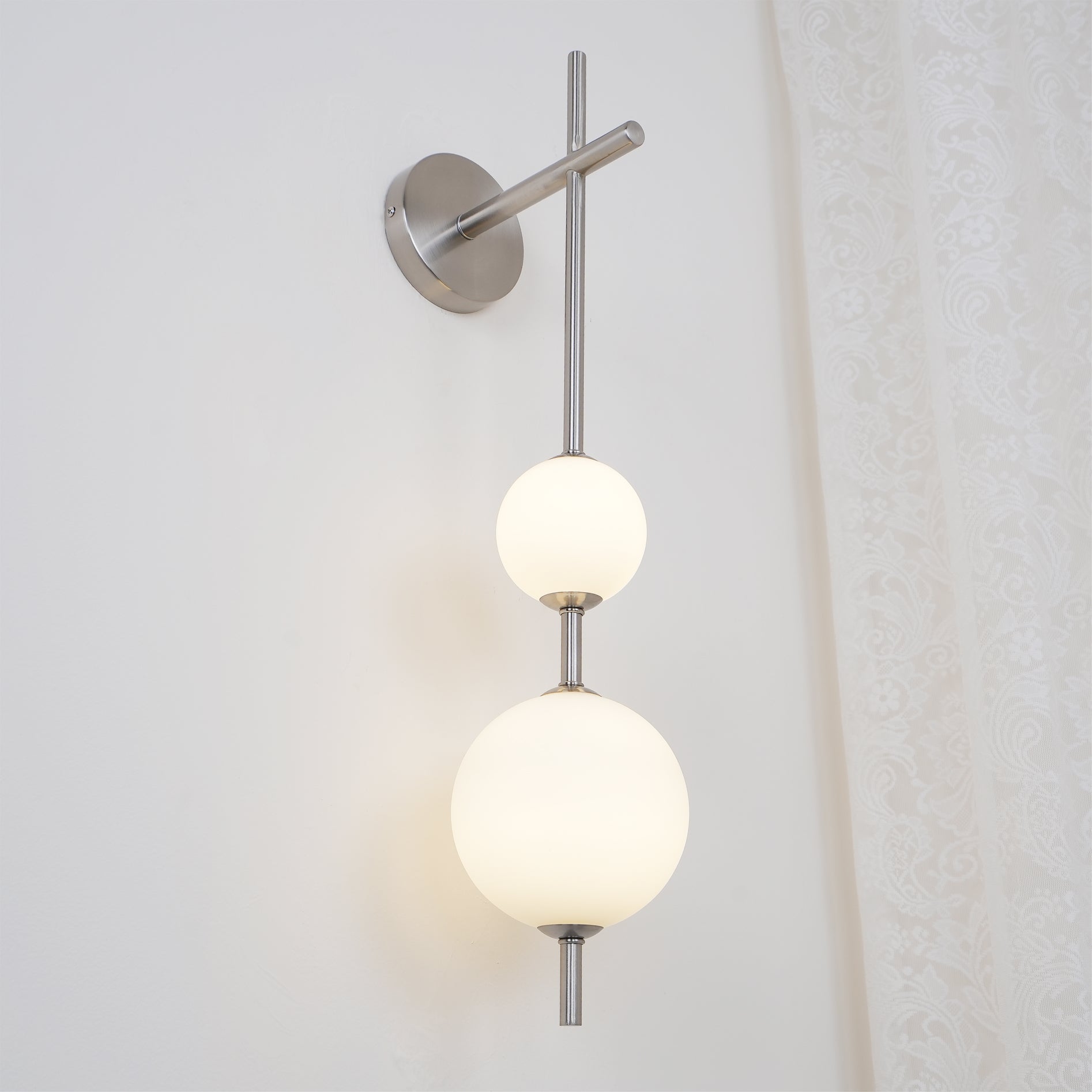 "Elegant vegglampe i glass og messing med kuleformede skjermer for mykt lys, perfekt for moderne og klassiske hjem."
