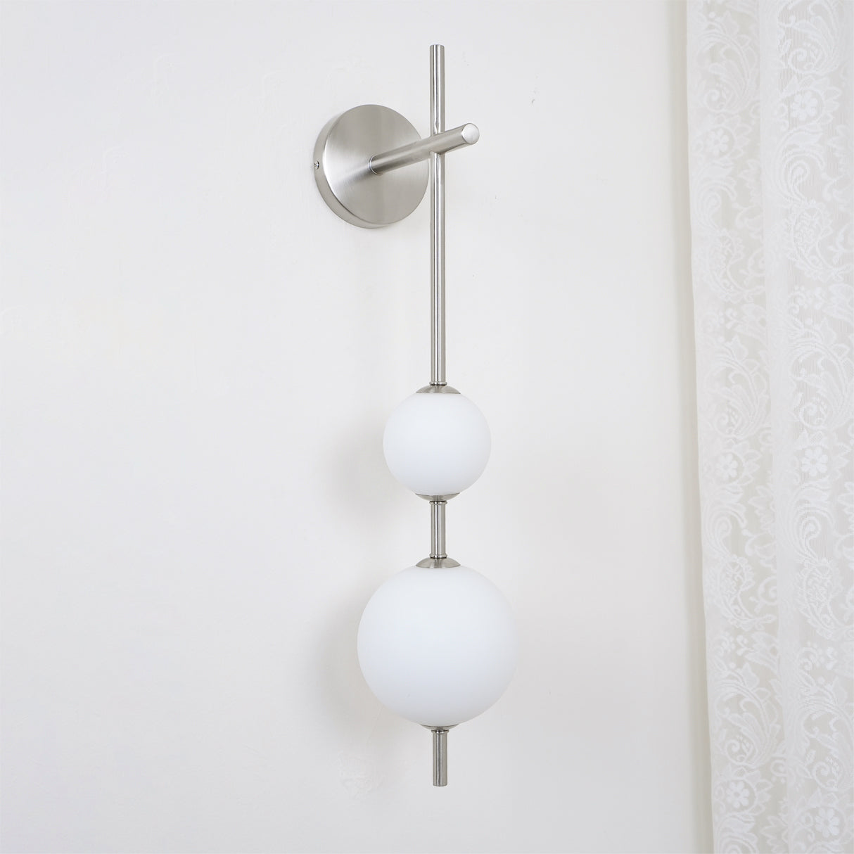 "Elegant vegglampe i glass og messing med kuleformede skjermer for mykt lys, perfekt for moderne og klassiske hjem."