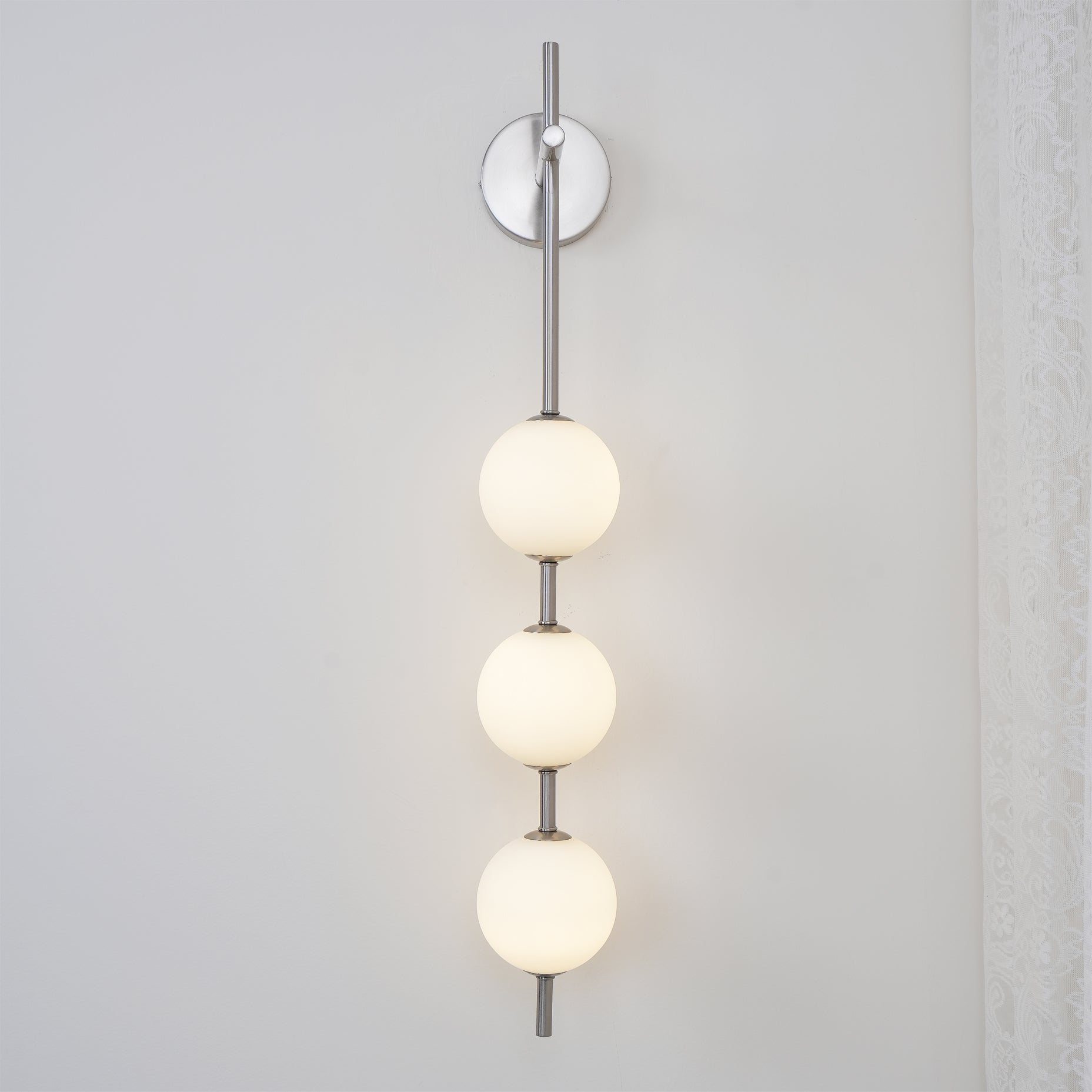 "Elegant vegglampe i glass og messing med kuleformede skjermer for mykt lys, perfekt for moderne og klassiske hjem."