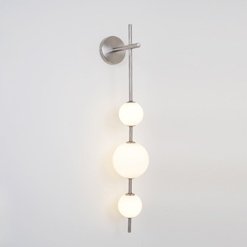 "Elegant vegglampe i glass og messing med kuleformede skjermer for mykt lys, perfekt for moderne og klassiske hjem."