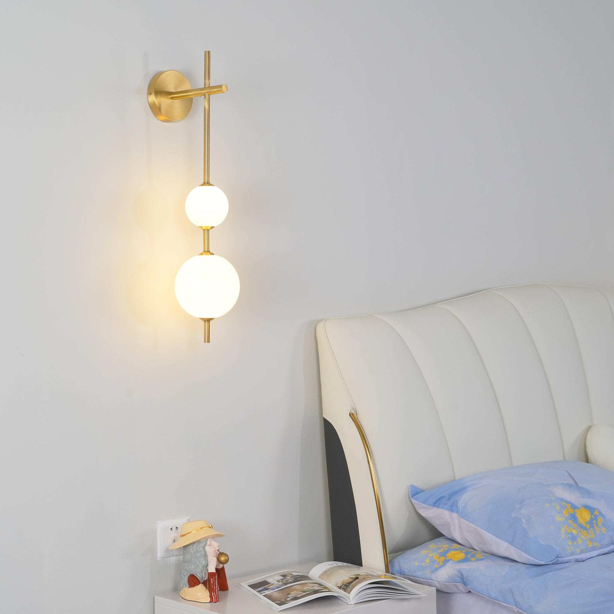 "Elegant vegglampe i glass og messing med kuleformede skjermer for mykt lys, perfekt for moderne og klassiske hjem."