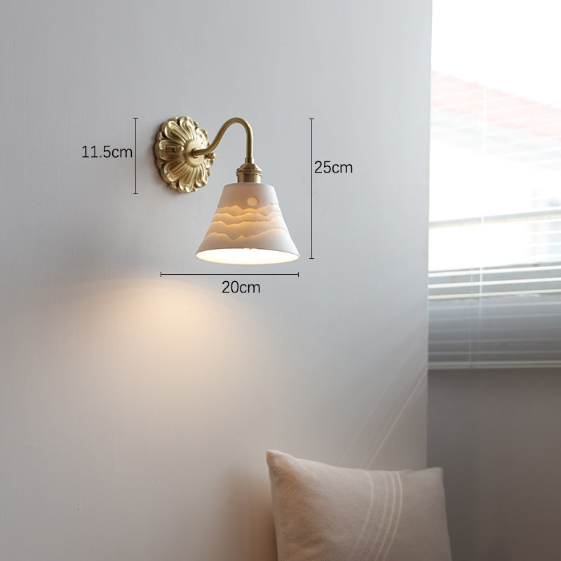 "Elegant vegglampe i messing og keramikk med antikk finish og hvit lampeskjerm, gir klassisk preg til interiøret."