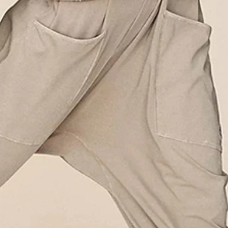 "Enkel jumpsuit med V-hals i ensfarget design, avslappet passform, racerback-stil, og lommer for praktisk bruk."