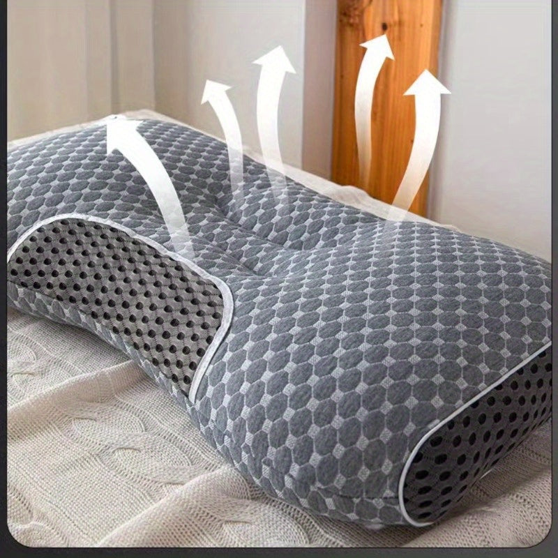 Hvit ergonomisk nakkepute vist i bruk på en seng, illustrerer god hode- og nakkestøtte.
