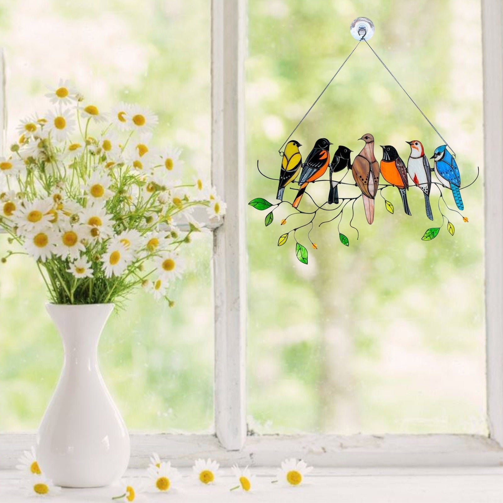 Fugledekorasjon i farget glass, hengende foran et vindu, skaper fargerike refleksjoner, unikt design