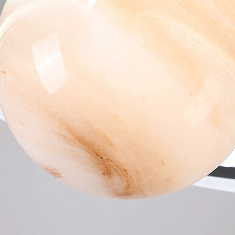 Moderne LED pendellampe med futuristisk planetdesign henger over spisebord, dimbar lys.