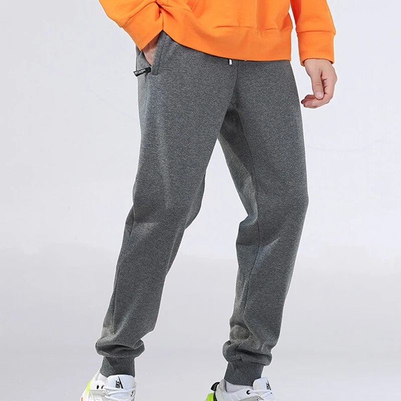 Myk og komfortabel herre joggebukse i grå med glidelåslommer for stil og funksjonalitet.
