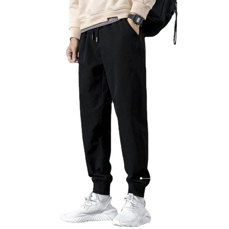 Herre joggebukse i svart for aktiv bruk, med glidelåslommer for trygg oppbevaring under trening.
