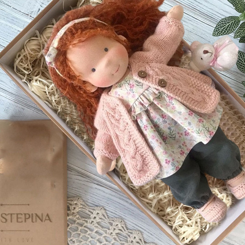 Håndlaget Waldorf-dukke i økologisk bomull med polka dots, brun og lilla kjole. Perfekt for småbarn, myk og trygg.