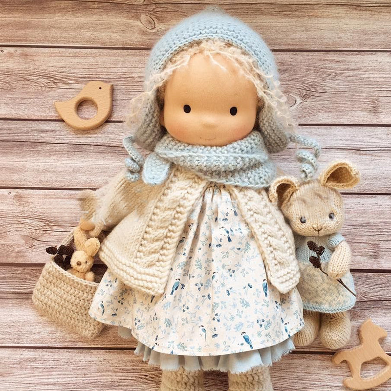 Håndlaget Waldorf-dukke i økologisk bomull med polka dots, brun og lilla kjole. Perfekt for småbarn, myk og trygg.