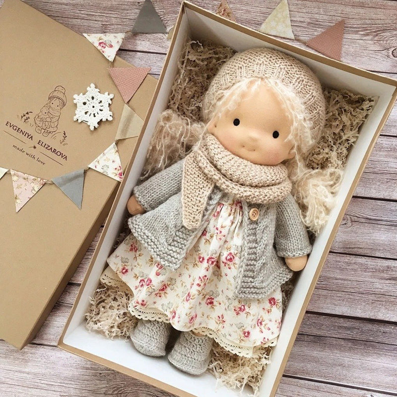 Håndlaget Waldorf-dukke i økologisk bomull med polka dots, brun og lilla kjole. Perfekt for småbarn, myk og trygg.