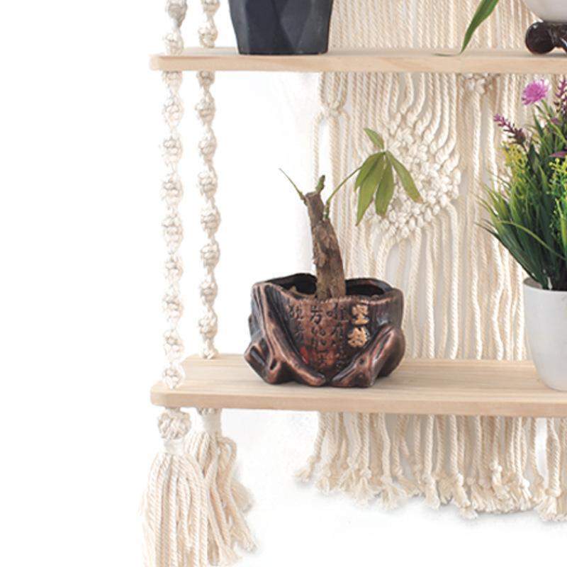 Elegant macramé vegghylle med trehylle, ideell for å vise frem små gjenstander i boho-interiør.