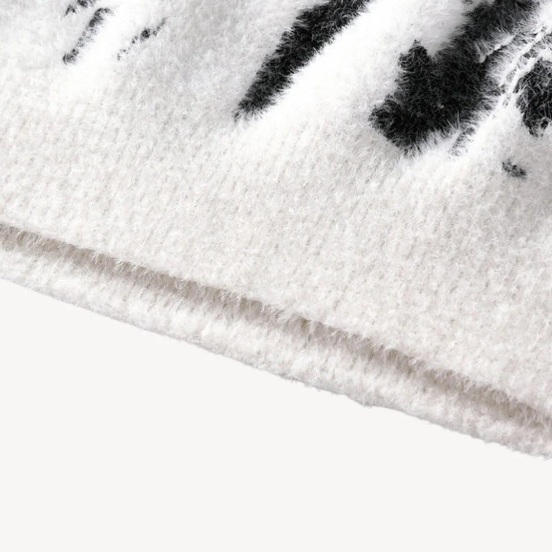 Nærbilde av den myke herregenseren med detaljert kumønster og rund hals. Unikt design for herremote.