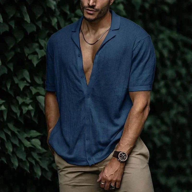 Mann med oppbrettede ermer på en stilfull linskjorte. Perfekt casual herreskjorte for varm sommer.