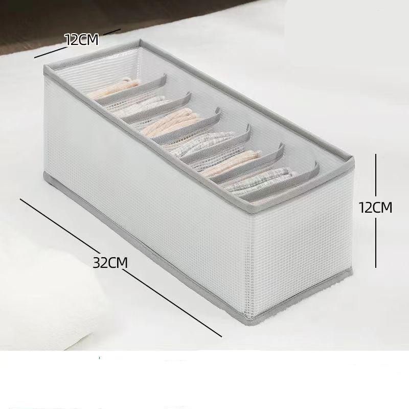 Detaljbilde av hvit stofforganisator med tekstur. Enkel sammenleggbar design for smart oppbevaring i klesskap.