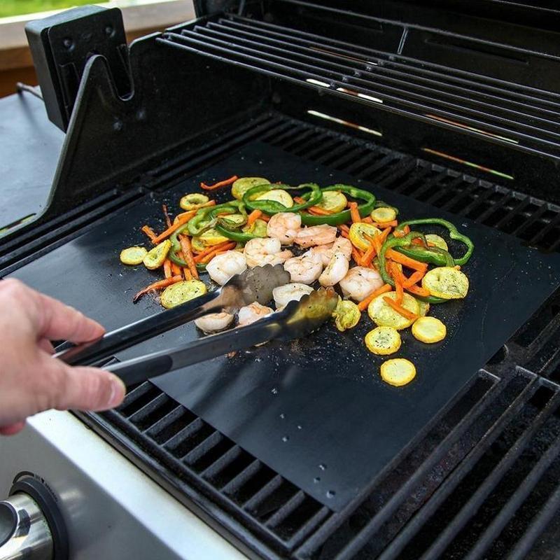 Ikke klebende grillmatte med slitesterk, svart overflate. Ideell for ren grilling, hindrer at mat faller gjennom risten.