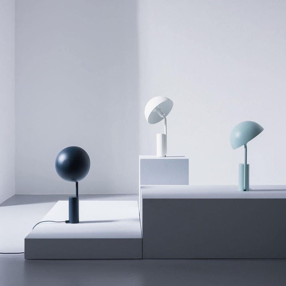"Justerbar og stilfull Cap bordlampe med geometriske former, tilgjengelig i hvit, rosa og svart. Perfekt for moderne interiør