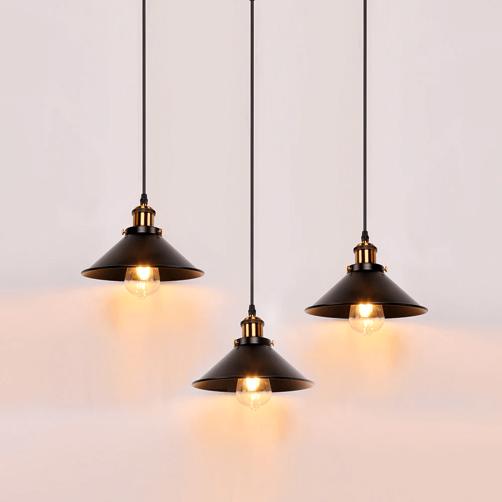Kjegleformet pendellampe i antikk messing med svart aksent, vintage industridesign, justerbar kabel for stilfull belysning.