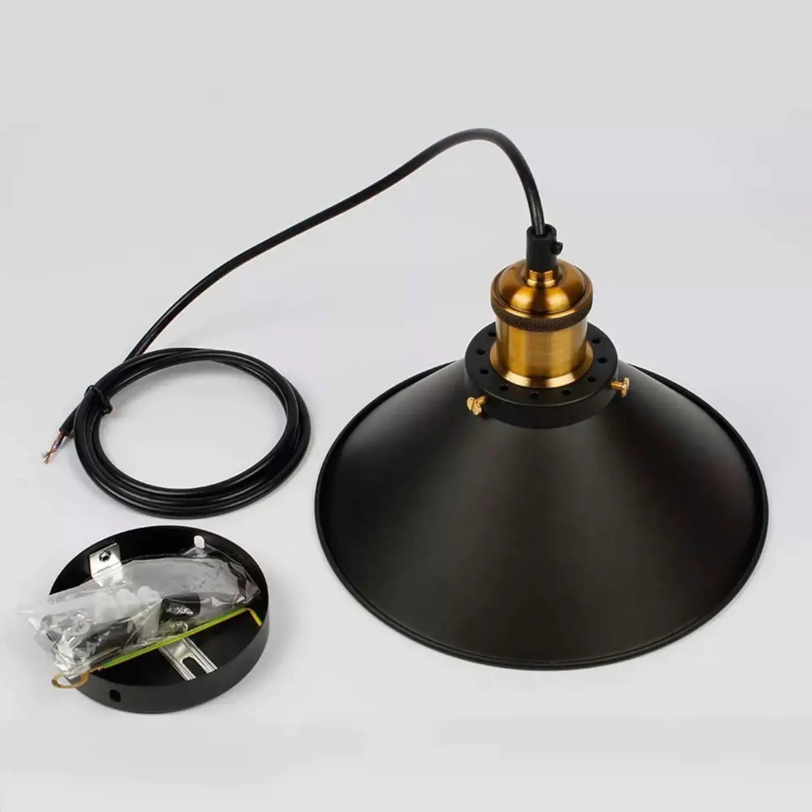 Kjegleformet pendellampe i antikk messing med svart aksent, vintage industridesign, justerbar kabel for stilfull belysning.