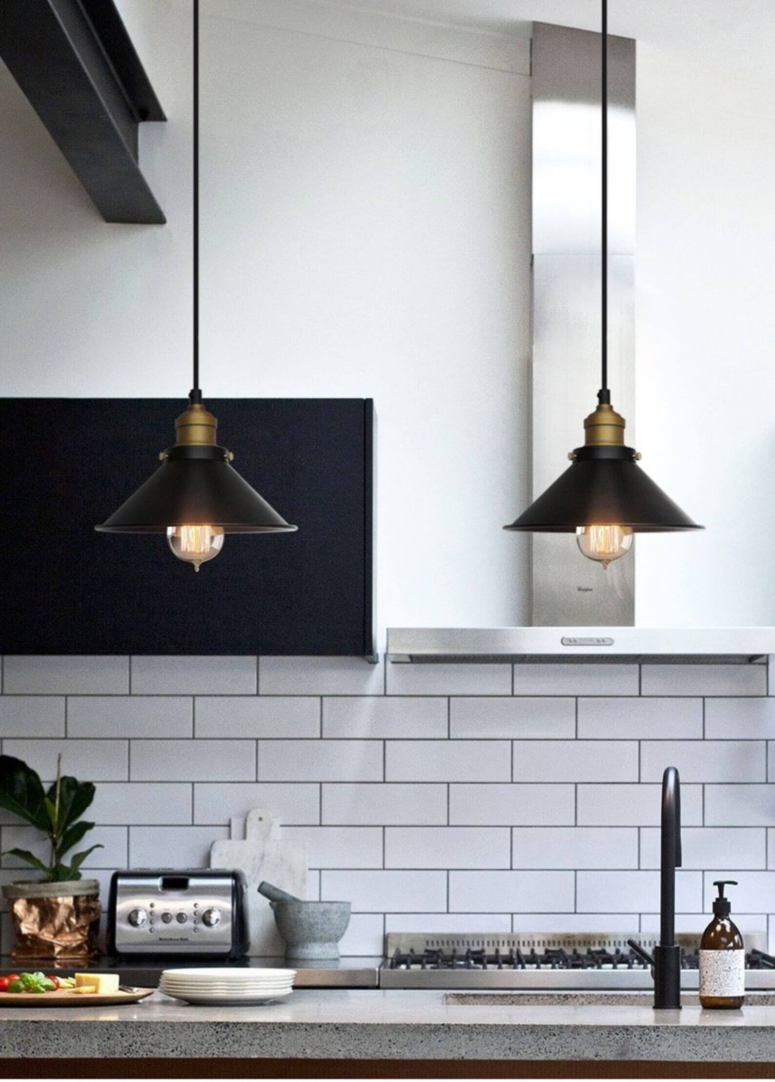Kjegleformet pendellampe i antikk messing med svart aksent, vintage industridesign, justerbar kabel for stilfull belysning.