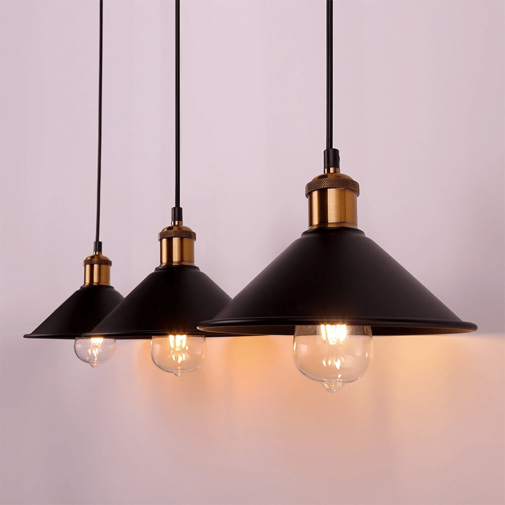 Kjegleformet pendellampe i antikk messing med svart aksent, vintage industridesign, justerbar kabel for stilfull belysning.