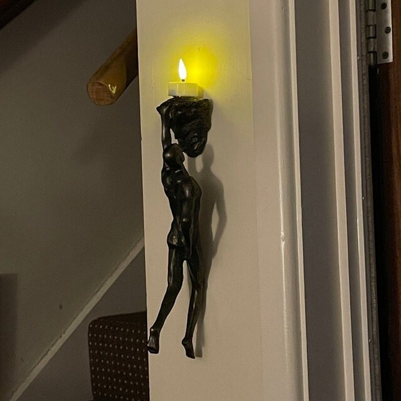 "Klatrende svart veggstatue i 3D resindesign, gir kunstnerisk preg og dybde til hjemmets interiør. Enkel installasjon."