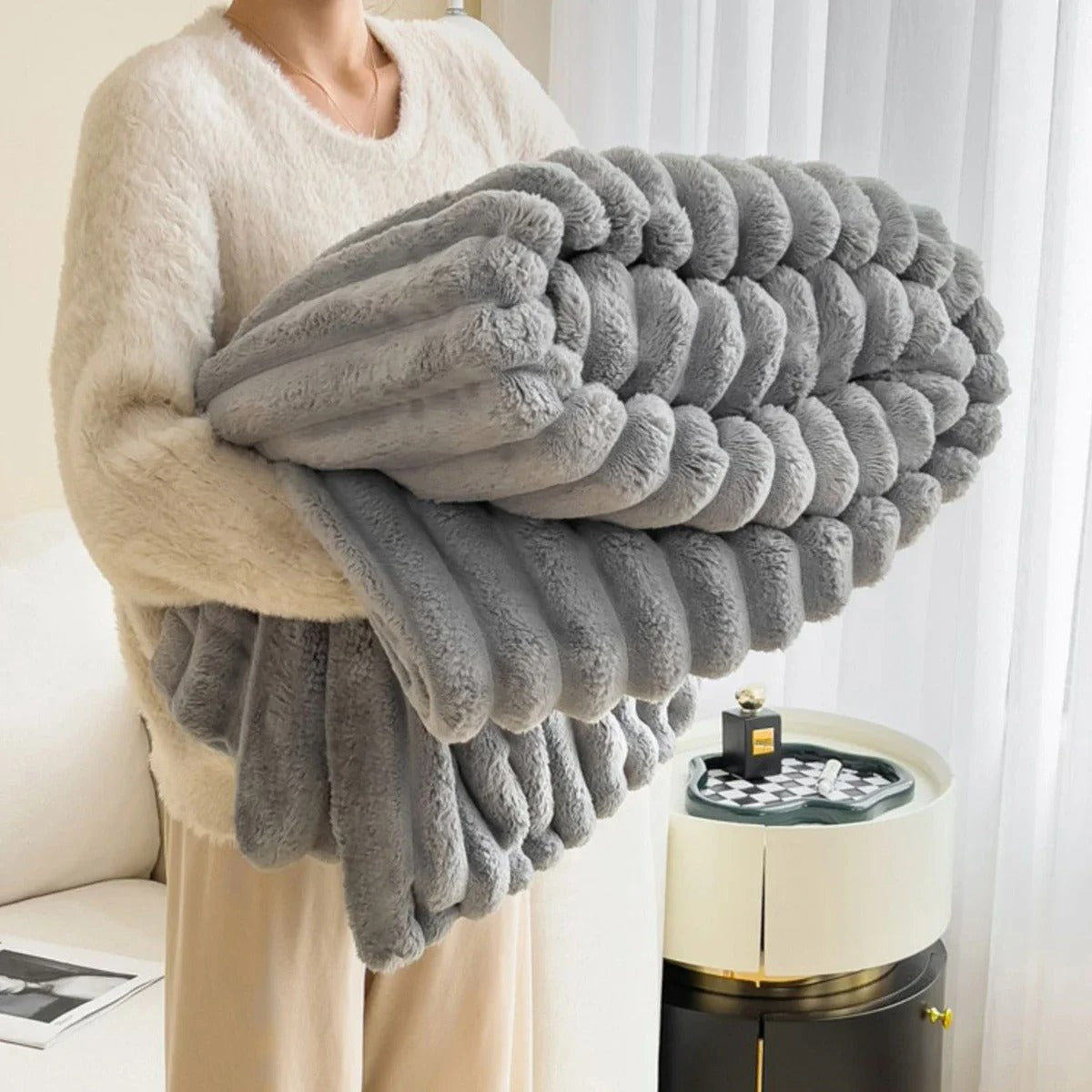 Rutete pledd brukt som et dekorativt element i en minimalistisk interiørsetting, skaper komfort.