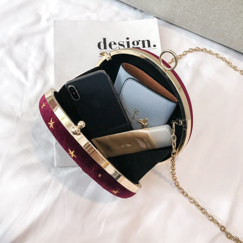 Detaljert bilde av fløyelsveskens stjerne- og månedesign, fremhever det kosmiske temaet på denne kvinnevesken