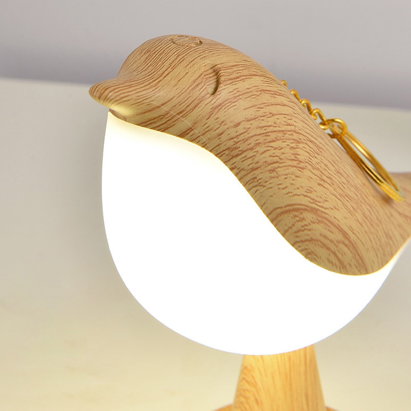 "Kremhvit fuglelampe med elegant design og LED-lys, ideell for moderne interiør, står på solid base."